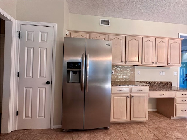 15598 S Blackfeather St, Olathe, KS 66062 - kitchen with stainless steel refrigerator with ice dispenser, dark stone counters, a textured ceiling, light tile patterned floors, and light brown cabinetry