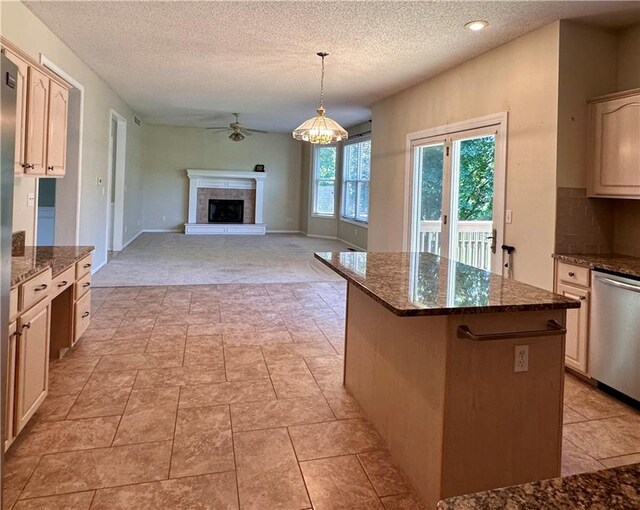 15598 S Blackfeather St, Olathe, KS 66062 - kitchen featuring stainless steel dishwasher, ceiling fan, a center island, a textured ceiling, and a fireplace with raised hearth