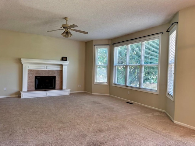 15598 S Blackfeather St, Olathe, KS 66062 - unfurnished living room featuring a ceiling fan, light colored carpet, a textured ceiling, and a tiled fireplace