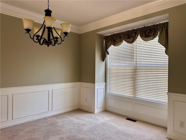 15598 S Blackfeather St, Olathe, KS 66062 - unfurnished room featuring a chandelier, crown molding, wainscoting, light carpet, and a textured ceiling