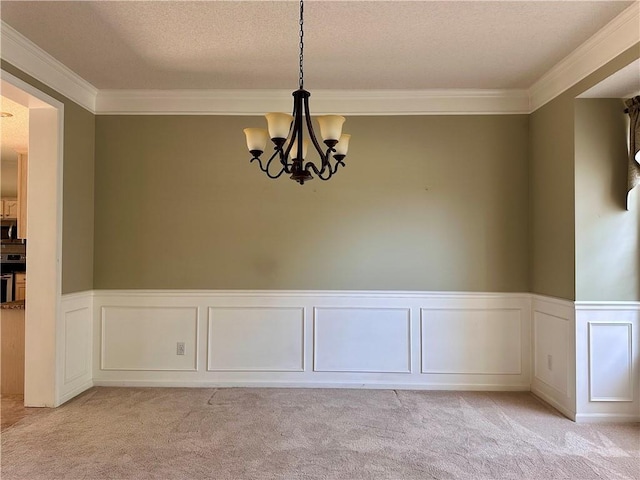 15598 S Blackfeather St, Olathe, KS 66062 - unfurnished dining area with light carpet, crown molding, a chandelier, wainscoting, and a textured ceiling