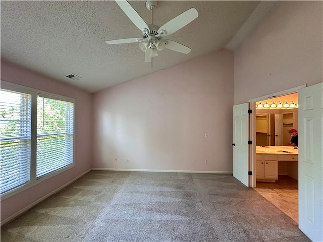 15598 S Blackfeather St, Olathe, KS 66062 - unfurnished bedroom with light colored carpet, vaulted ceiling, a textured ceiling, ensuite bathroom, and a ceiling fan