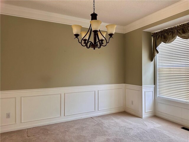 15598 S Blackfeather St, Olathe, KS 66062 - empty room featuring a chandelier, plenty of natural light, light colored carpet, crown molding, and a decorative wall