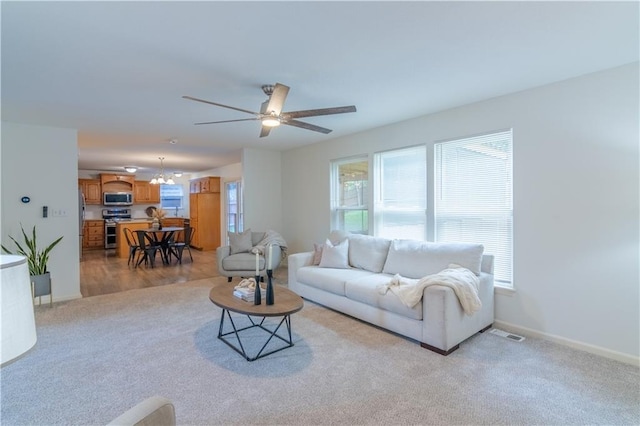 404 Wyndham Dr, Lansing, KS 66043 - living area featuring light colored carpet, ceiling fan, and a chandelier