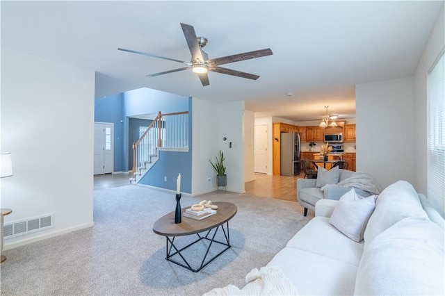 404 Wyndham Dr, Lansing, KS 66043 - living area featuring stairway, light colored carpet, a chandelier, and ceiling fan