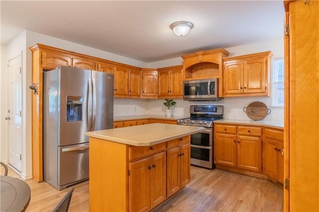 404 Wyndham Dr, Lansing, KS 66043 - kitchen with stainless steel appliances, light countertops, light wood-type flooring, a kitchen island, and brown cabinets