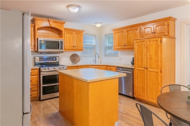 404 Wyndham Dr, Lansing, KS 66043 - kitchen featuring appliances with stainless steel finishes, light countertops, light wood-type flooring, and a center island