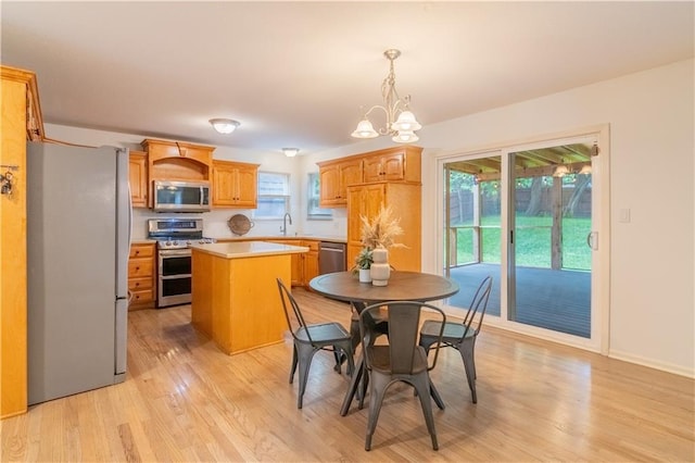 404 Wyndham Dr, Lansing, KS 66043 - dining space featuring light wood finished floors, a chandelier, and plenty of natural light