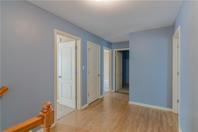 404 Wyndham Dr, Lansing, KS 66043 - hallway with light wood-type flooring and a textured ceiling