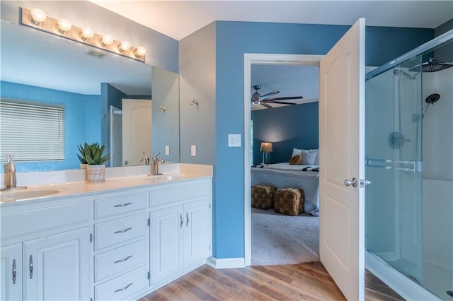 404 Wyndham Dr, Lansing, KS 66043 - full bathroom with ensuite bathroom, wood finished floors, a ceiling fan, a shower stall, and double vanity