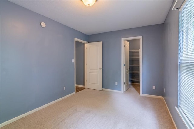 404 Wyndham Dr, Lansing, KS 66043 - unfurnished bedroom featuring carpet, a walk in closet, and a closet