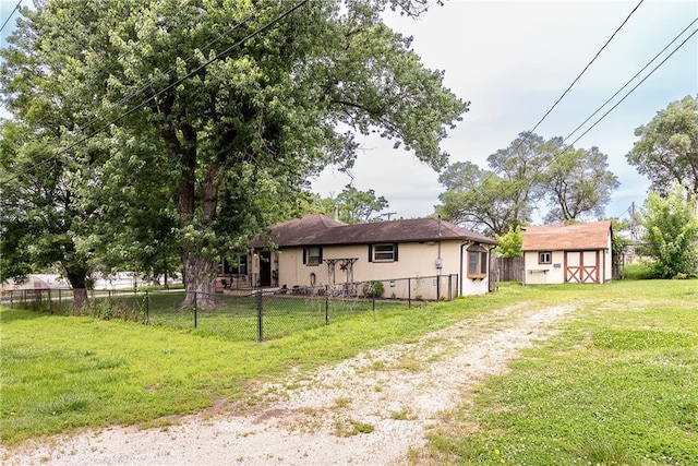 3722 Robinson Pike Rd, Grandview, MO 64030 - back of house with a shed, stucco siding, and driveway
