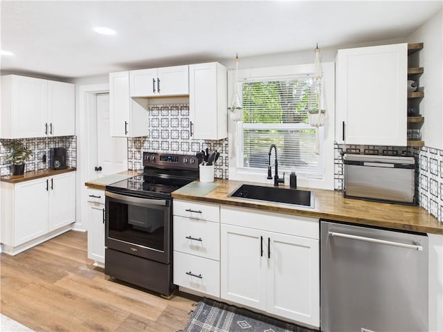 307 E 4th St, Holden, MO 64040 - kitchen featuring electric range, stainless steel dishwasher, wood counters, tasteful backsplash, and recessed lighting
