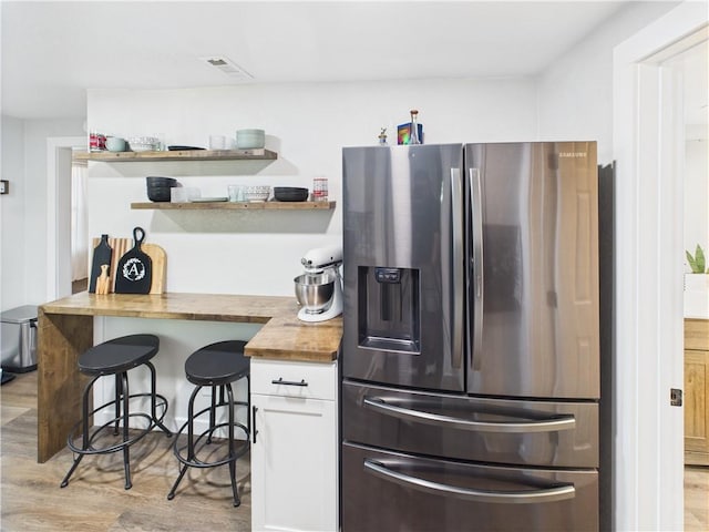 307 E 4th St, Holden, MO 64040 - kitchen featuring stainless steel fridge with ice dispenser, wooden counters, white cabinetry, open shelves, and light wood-style flooring
