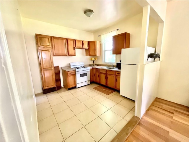 1870 N 27th St, Kansas City, KS 66104 - kitchen with white appliances, light countertops, and brown cabinetry