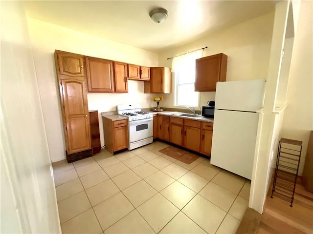 1870 N 27th St, Kansas City, KS 66104 - kitchen with white appliances, brown cabinetry, light countertops, and light tile patterned floors