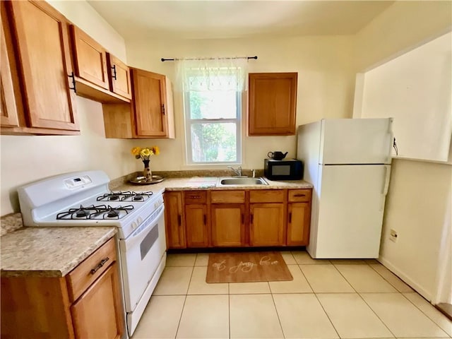 1870 N 27th St, Kansas City, KS 66104 - kitchen featuring white appliances, brown cabinets, light countertops, and light tile patterned flooring