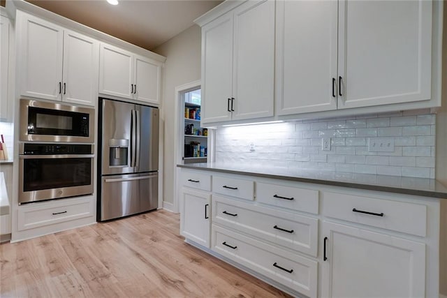 25411 W 142nd Pl, Olathe, KS 66061 - kitchen with appliances with stainless steel finishes, white cabinetry, tasteful backsplash, and light wood-style flooring
