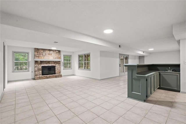 9602 W 116th St, Overland Park, KS 66210 - kitchen with healthy amount of natural light, a fireplace, recessed lighting, light tile patterned floors, and a peninsula
