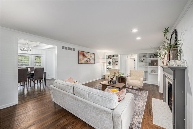 3818 W 52nd Ter, Roeland Park, KS 66205 - living room featuring a chandelier, crown molding, a fireplace, dark wood finished floors, and built in shelves