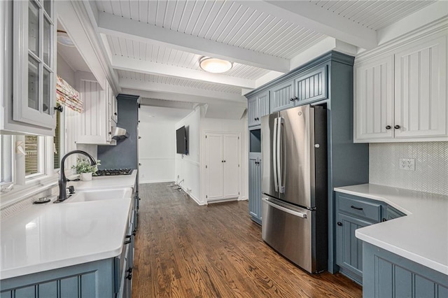 3818 W 52nd Ter, Roeland Park, KS 66205 - kitchen with appliances with stainless steel finishes, tasteful backsplash, blue cabinets, beam ceiling, and dark wood-style floors