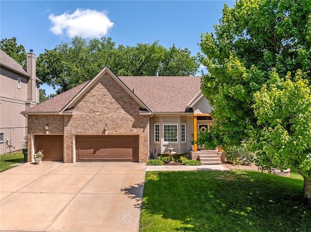 14740 W 128th St, Olathe, KS 66062 - view of front of home with a front lawn, driveway, an attached garage, and brick siding