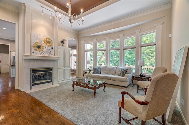 14740 W 128th St, Olathe, KS 66062 - living area featuring crown molding, wood finished floors, a tiled fireplace, and a chandelier