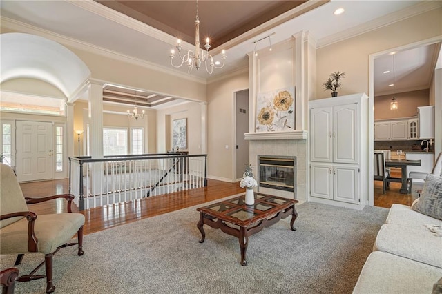 14740 W 128th St, Olathe, KS 66062 - living area featuring a chandelier, a tray ceiling, crown molding, a tiled fireplace, and wood finished floors