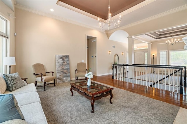 14740 W 128th St, Olathe, KS 66062 - living room with a raised ceiling, crown molding, a chandelier, wood finished floors, and ornate columns