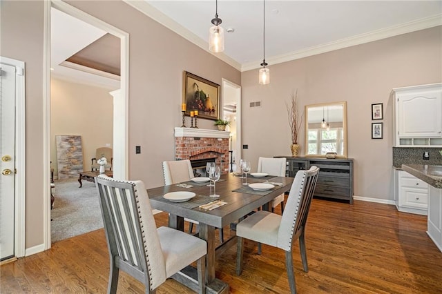 14740 W 128th St, Olathe, KS 66062 - dining space featuring crown molding, a fireplace, and wood finished floors