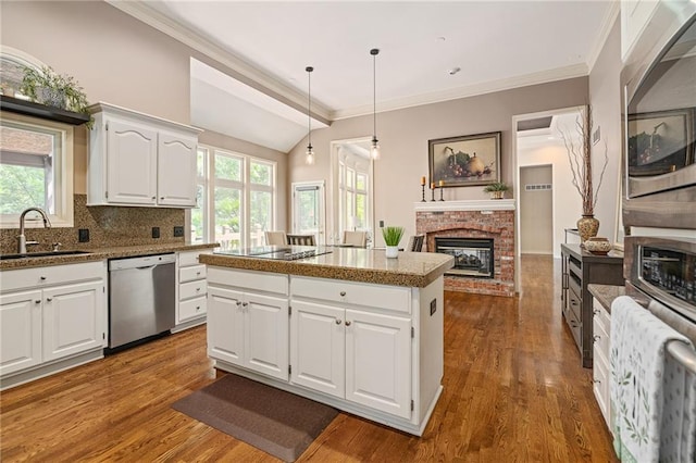 14740 W 128th St, Olathe, KS 66062 - kitchen featuring stainless steel dishwasher, a brick fireplace, a center island, black electric stovetop, and wood finished floors