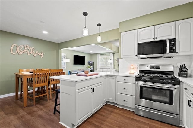 22420 W 73rd Ter, Shawnee, KS 66227 - kitchen with stainless steel appliances, a peninsula, white cabinetry, dark wood-style flooring, and light countertops