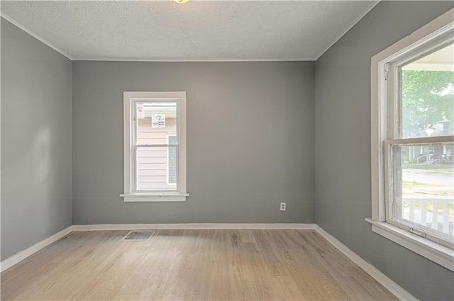 2524 Askew Ave, Kansas City, MO 64127 - empty room with light wood-type flooring, crown molding, and a textured ceiling