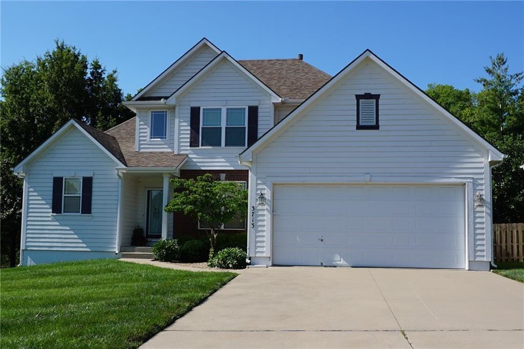 3713 NW Windburn Dr, Blue Springs, MO 64015 - traditional-style house with driveway, a front yard, a shingled roof, and an attached garage