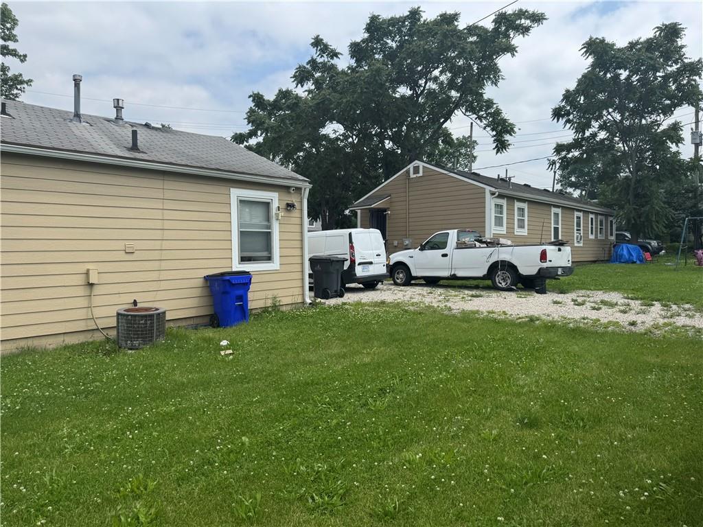 115 S Julia St, Olathe, KS 66061 - view of side of home featuring a lawn and a central air condition unit