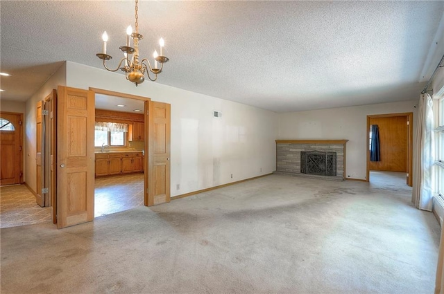 1933 N 83rd Ter, Kansas City, KS 66112 - unfurnished living room featuring a textured ceiling, carpet floors, a chandelier, and a brick fireplace