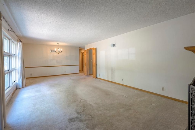 1933 N 83rd Ter, Kansas City, KS 66112 - empty room featuring a chandelier, a textured ceiling, and light colored carpet