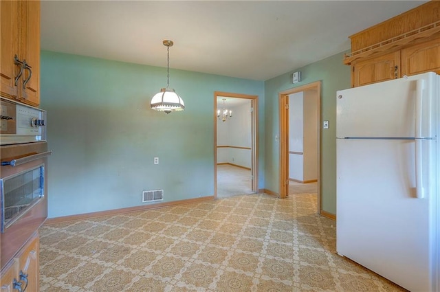 1933 N 83rd Ter, Kansas City, KS 66112 - kitchen with freestanding refrigerator, oven, light colored carpet, decorative light fixtures, and brown cabinetry