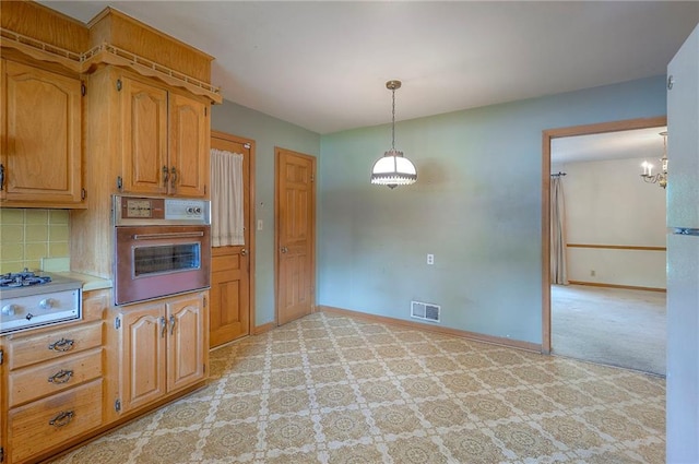 1933 N 83rd Ter, Kansas City, KS 66112 - kitchen featuring stainless steel oven, stovetop, light carpet, a chandelier, and hanging light fixtures