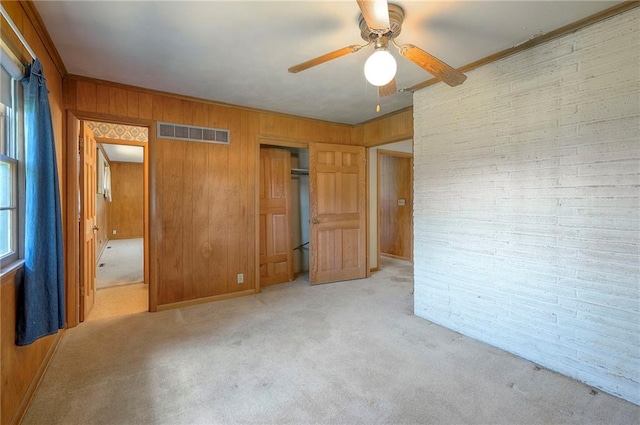 1933 N 83rd Ter, Kansas City, KS 66112 - unfurnished bedroom featuring wood walls, carpet floors, a closet, ornamental molding, and ceiling fan