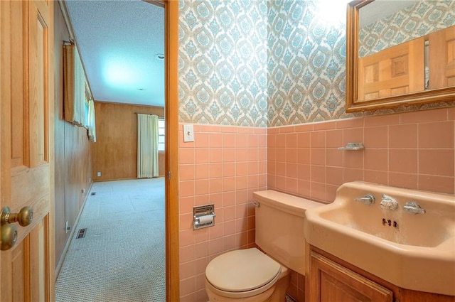 1933 N 83rd Ter, Kansas City, KS 66112 - half bathroom featuring wallpapered walls, vanity, and a wainscoted wall