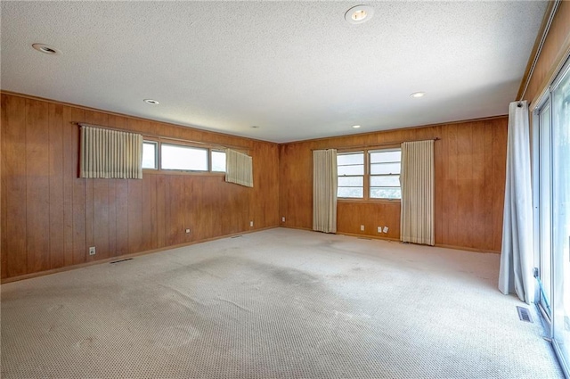 1933 N 83rd Ter, Kansas City, KS 66112 - unfurnished room with plenty of natural light, wood walls, light carpet, a textured ceiling, and recessed lighting
