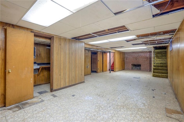 1933 N 83rd Ter, Kansas City, KS 66112 - finished below grade area with stairway, wood walls, tile patterned floors, and a fireplace