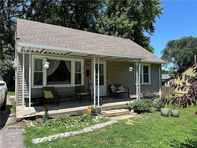 1212 S Harris Ave, Independence, MO 64052 - rear view of property with a porch, a shingled roof, and a lawn