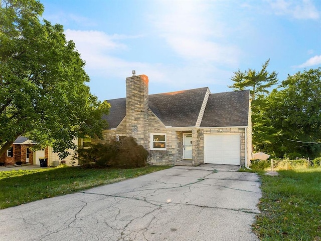 4428 N Monroe Ave, Kansas City, MO 64117 - tudor house featuring asphalt driveway, an attached garage, stone siding, roof with shingles, and a chimney