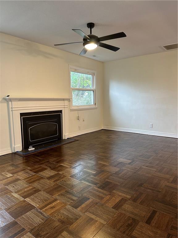 4428 N Monroe Ave, Kansas City, MO 64117 - unfurnished living room with ceiling fan and a fireplace