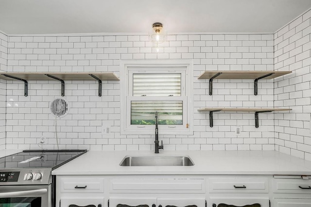 4428 N Monroe Ave, Kansas City, MO 64117 - kitchen featuring stainless steel electric stove, open shelves, decorative backsplash, white cabinets, and light countertops