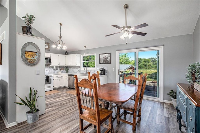 21318 S Briar Rd, Peculiar, MO 64078 - dining space with vaulted ceiling, a ceiling fan, light wood finished floors, and a chandelier