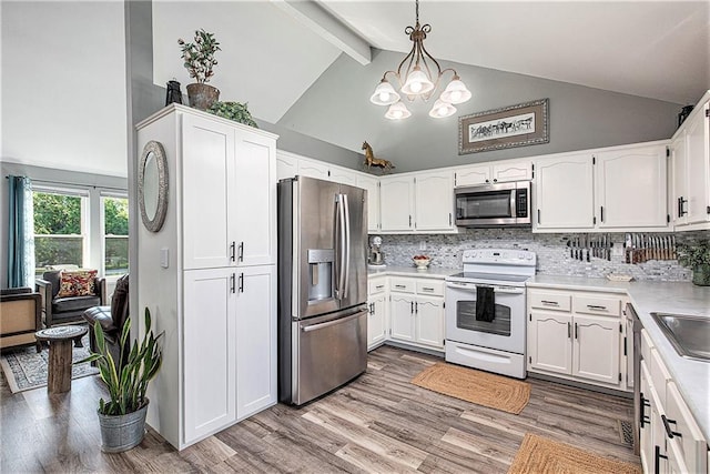 21318 S Briar Rd, Peculiar, MO 64078 - kitchen featuring stainless steel appliances, white cabinets, a chandelier, decorative backsplash, and beamed ceiling