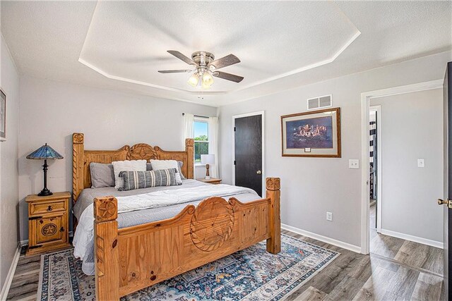 21318 S Briar Rd, Peculiar, MO 64078 - bedroom with wood finished floors, a raised ceiling, a textured ceiling, and ceiling fan
